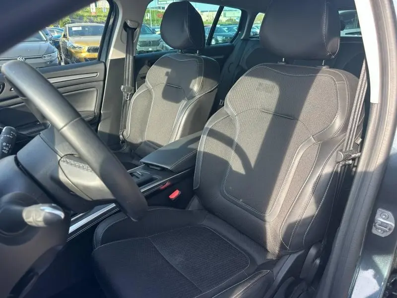 Vue intérieure de face des sièges avant noirs en similicuir et tissu de la Renault Mégane Break gris titanium 2024.