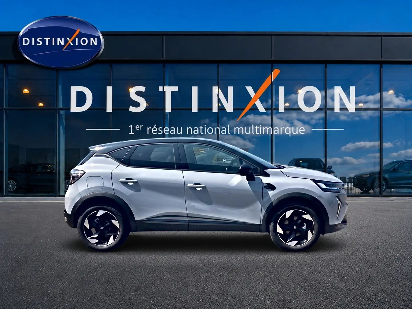 Profil droit du Renault Captur 2026 couleur Rafale avec toit noir et jantes alu noires devant un showroom Distinxion.