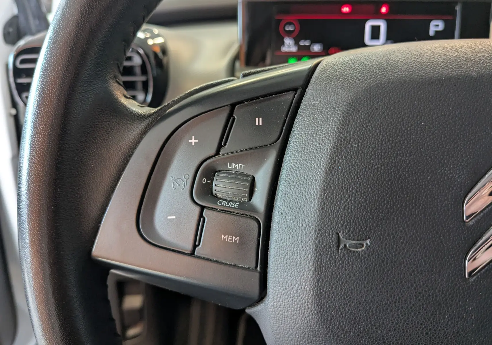 Gros plan sur le côté gauche du volant noir de la Citroën C4 Cactus 2019, avec commandes de régulateur de vitesse visibles.