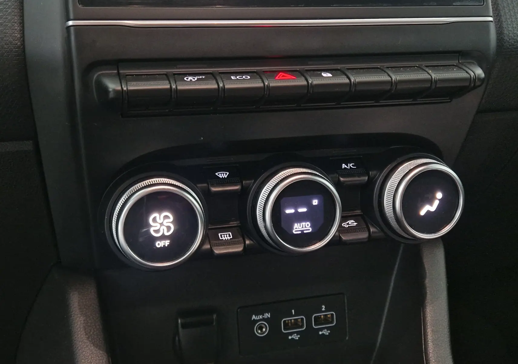 Détail du tableau de bord de la Renault Clio V gris platine 2021, montrant les commandes de climatisation et les ports USB.