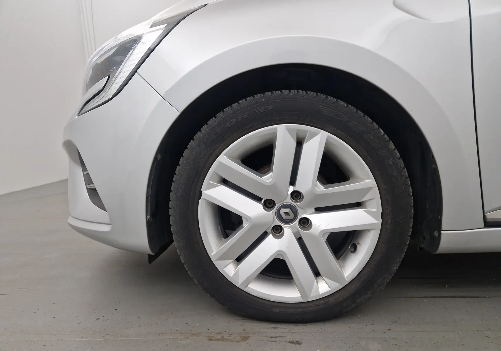 Gros plan sur la roue avant gauche gris platine d'une Renault Clio V 1.0 TCE 90 Zen avec jante alliage distinctive.