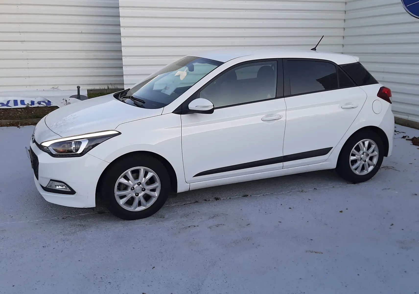 Hyundai i20 blanc vue de profil côté gauche, compacte 5 portes avec jantes alliage et vitres teintées.