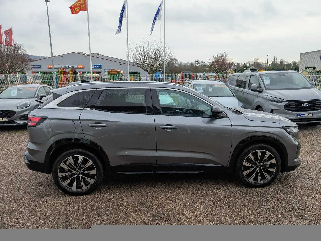 Renault Austral gris en vue de profil côté gauche, avec jantes alliage noires et vitres arrière surteintées.