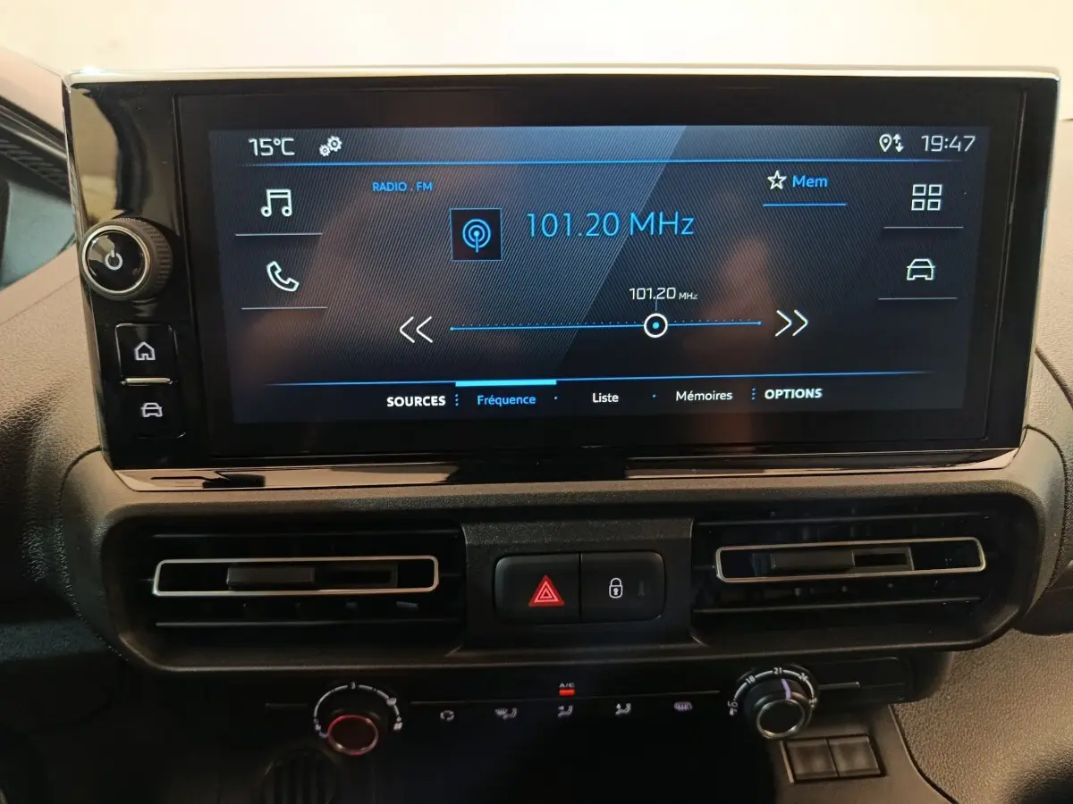 Écran tactile central du tableau de bord du Peugeot Partner blanc, affichant la radio FM à 101,20 MHz.