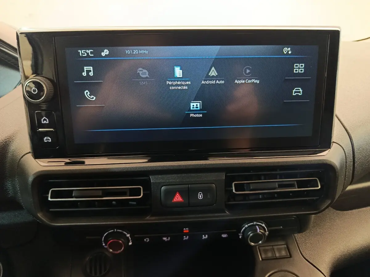 Écran tactile central du tableau de bord du Peugeot Partner 2025 avec commandes climatisation et boutons de sécurité.