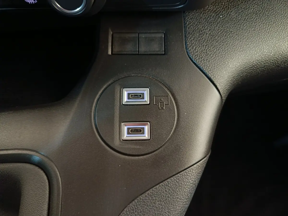 Gros plan sur les deux ports USB-C intégrés dans la console centrale noire du Peugeot Partner blanc 2025.