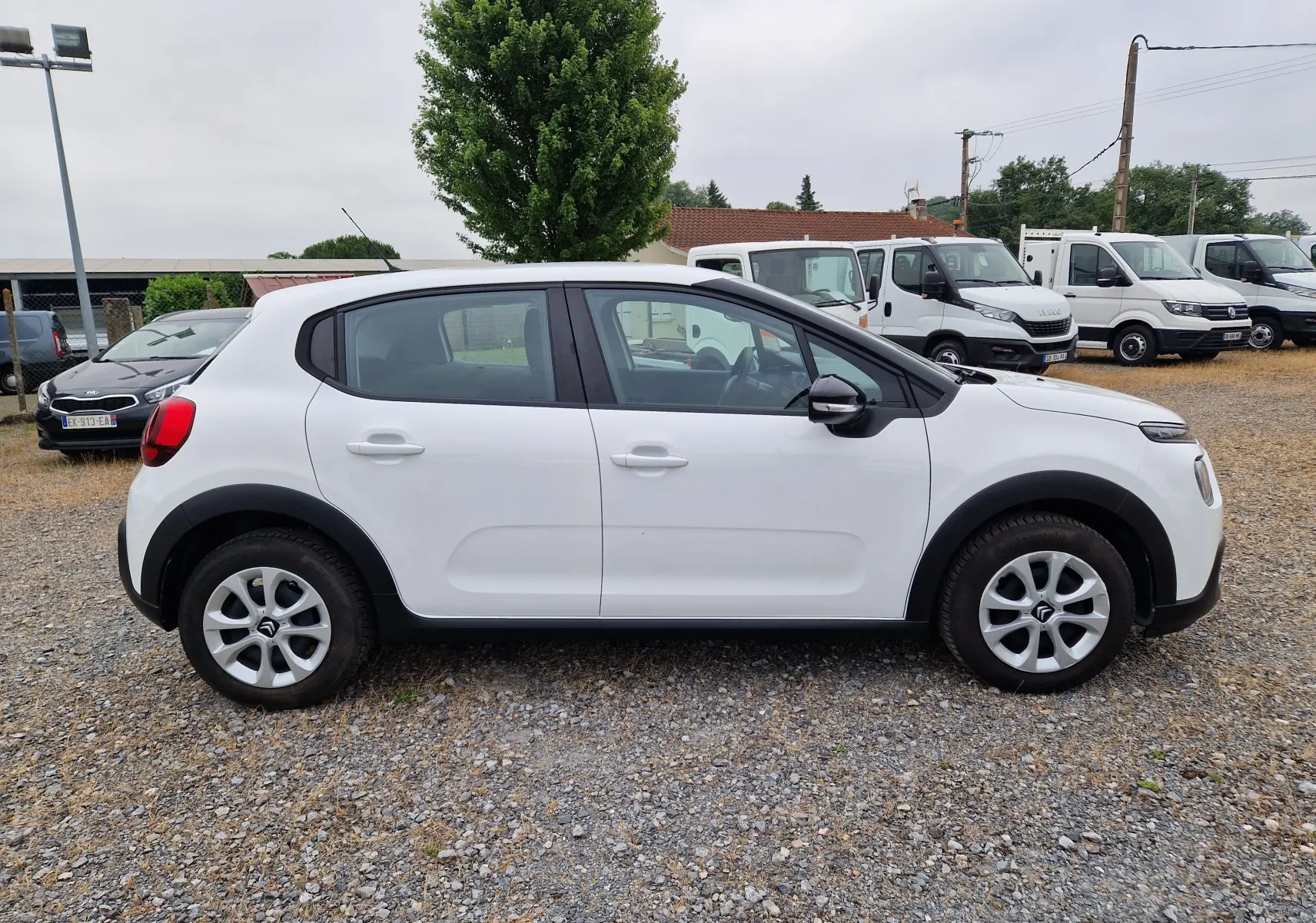 Vue de profil côté gauche d'une Citroën C3 Société blanche, avec jantes en alliage et protections noires sur les passages de roues.