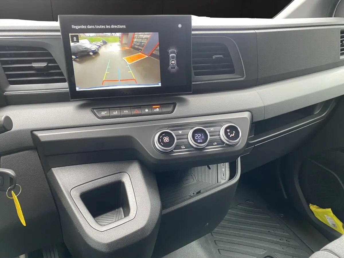 Vue intérieure du tableau de bord du Renault Master 2026, avec écran tactile affichant la caméra de recul et commandes climatisation.