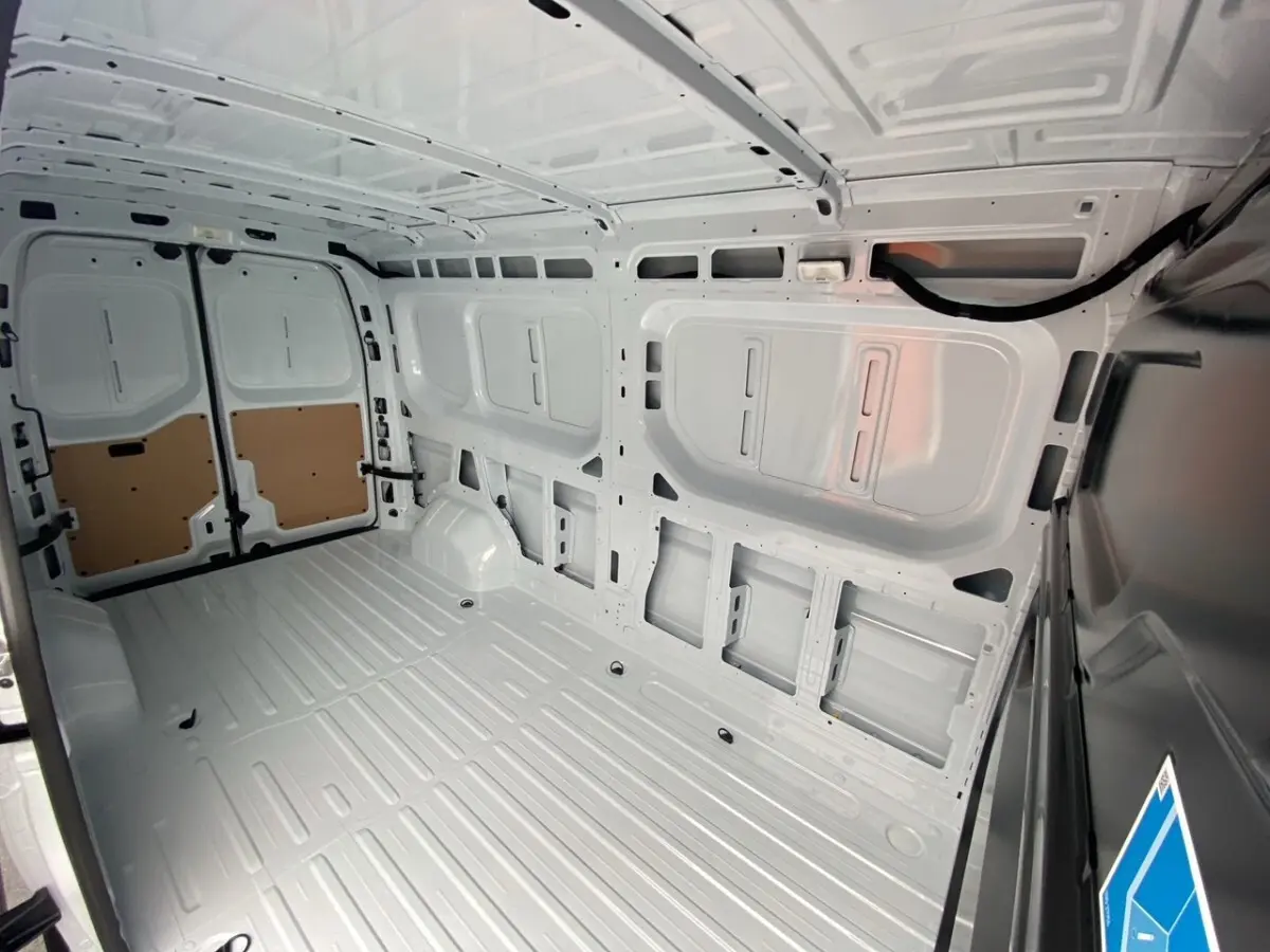 Vue intérieure arrière du Renault Master blanc, montrant l’espace de chargement vide et la cloison pleine.