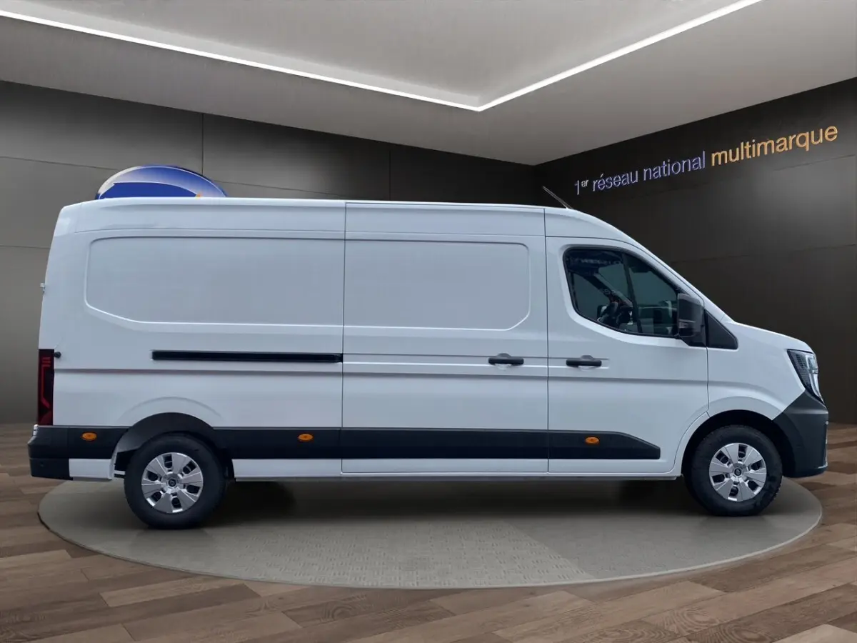 Vue de profil côté gauche d’un Renault Master blanc, fourgon long avec protections noires et jantes argentées.