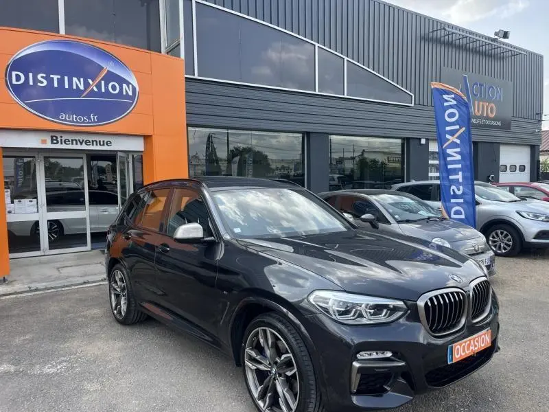 BMW X3 M40iA Sophistograu métallisé en 3/4 avant droit, avec jantes 21 pouces et calandre double haricot visible.