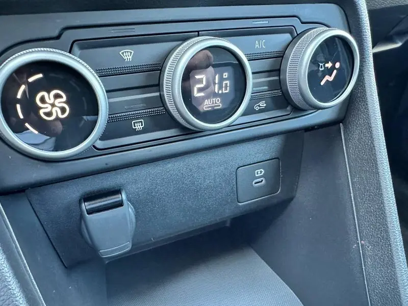 Gros plan sur les commandes de climatisation automatique et prise USB du tableau de bord de la Dacia Sandero beige Safari 2025.