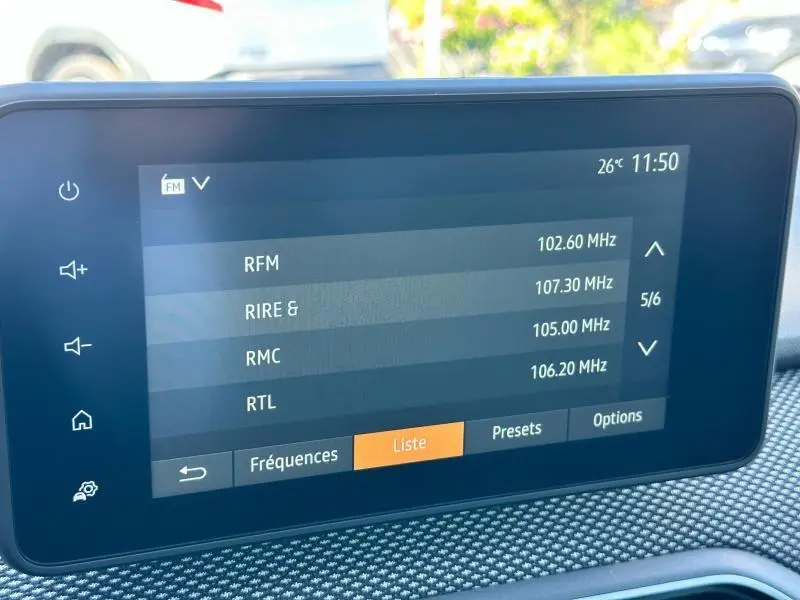 Écran tactile central de la Dacia Sandero 2025 affichant la liste des stations radio FM avec interface moderne.
