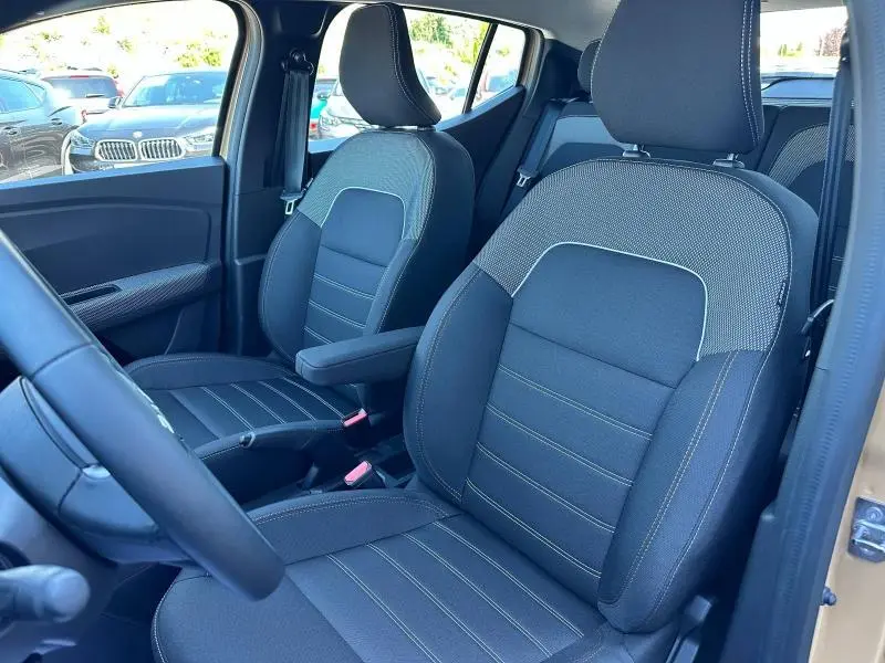 Vue intérieure côté gauche montrant les sièges avant en tissu Stepway noir avec surpiqûres, dans une Dacia Sandero Beige Safari 2025.