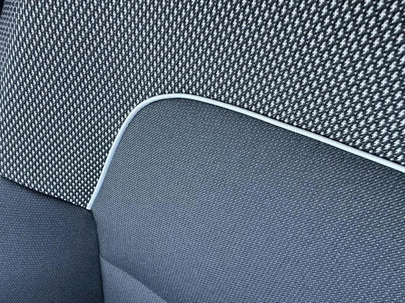 Gros plan sur le tissu Stepway gris foncé avec surpiqûres claires de la banquette d'une Dacia Sandero beige Safari 2025