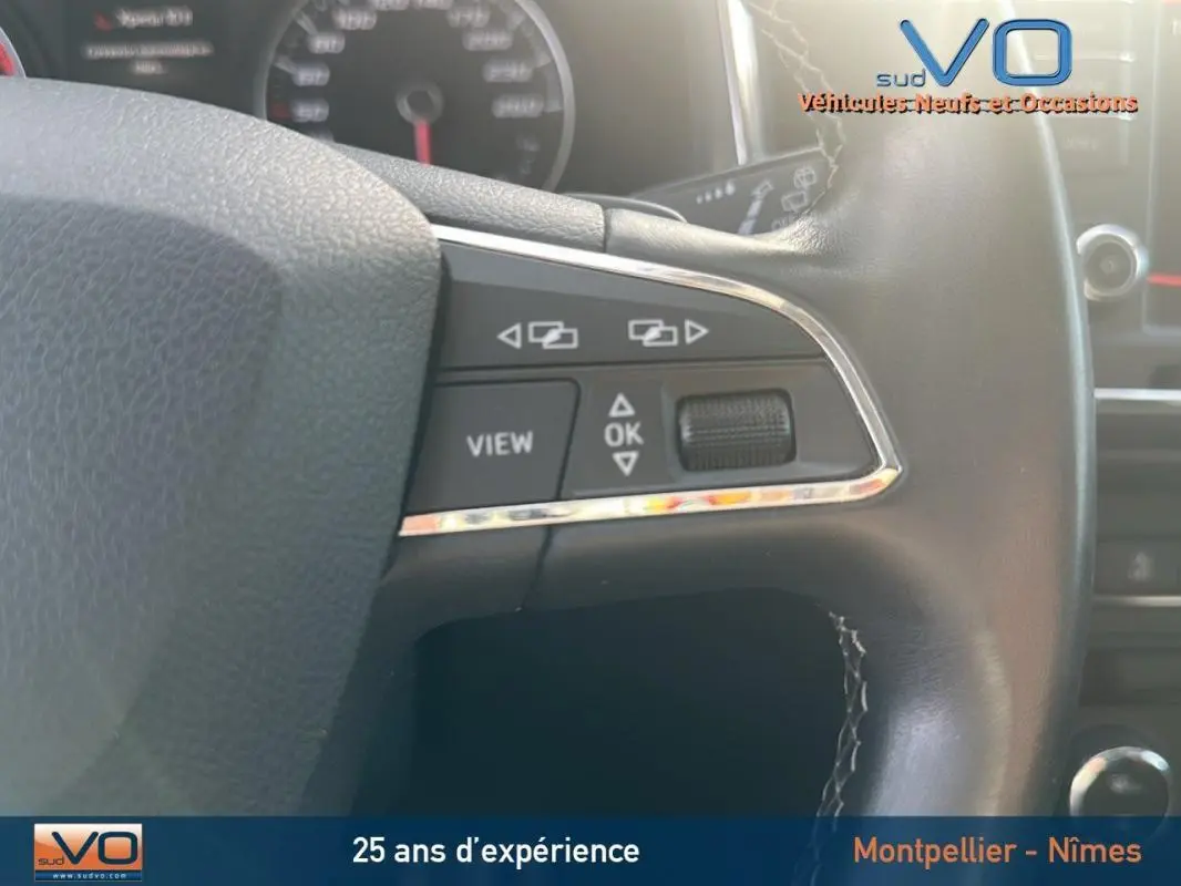 Gros plan sur le volant multifonctions en cuir de la SEAT Ateca bleu foncé, montrant les commandes de navigation et de vue.