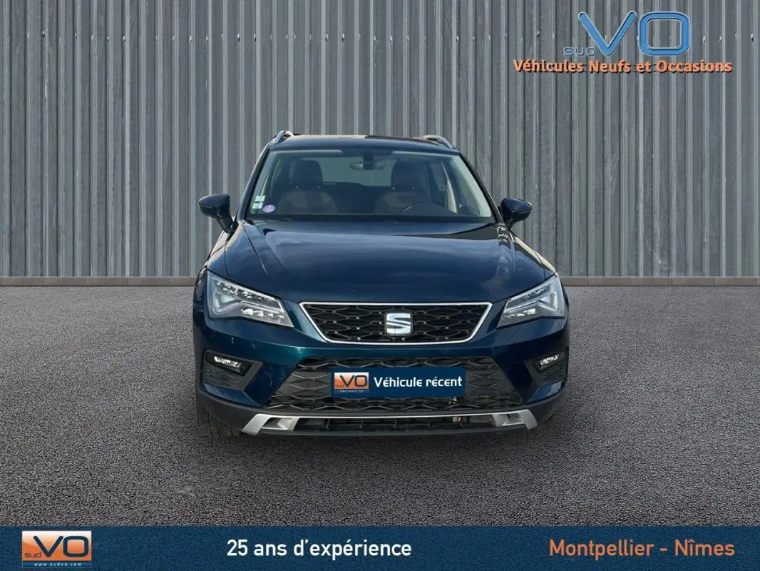 Vue frontale d'un SEAT Ateca bleu foncé 2019 avec calandre chromée et phares LED allumés.