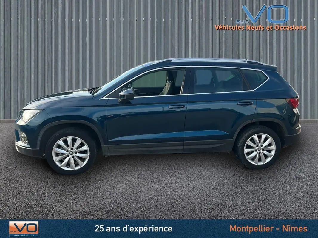 Profil latéral droit d'un SEAT Ateca bleu foncé 2019 avec jantes alliage 17 pouces et vitres teintées.