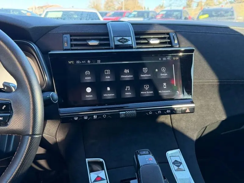 Vue intérieure du tableau de bord du DS7 E-TENSE 225ch 2024 avec écran tactile et commandes modernes en noir et gris.