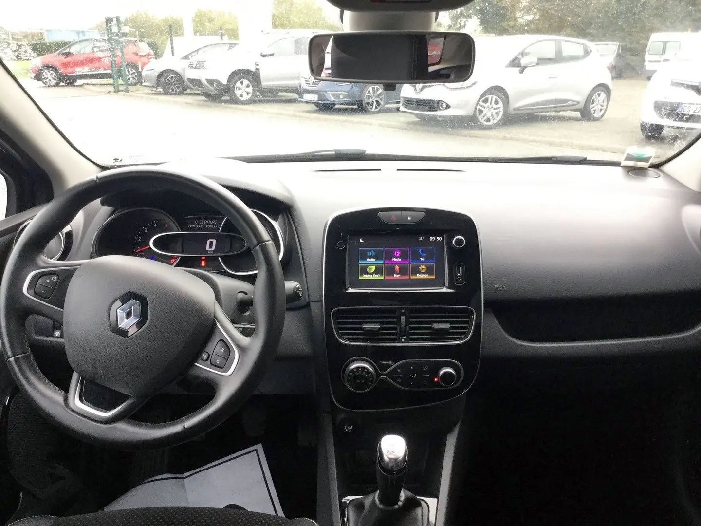 Vue intérieure avant du tableau de bord et volant noir d’une Renault Clio IV Estate TCE 90 Energy Intens de 2018.