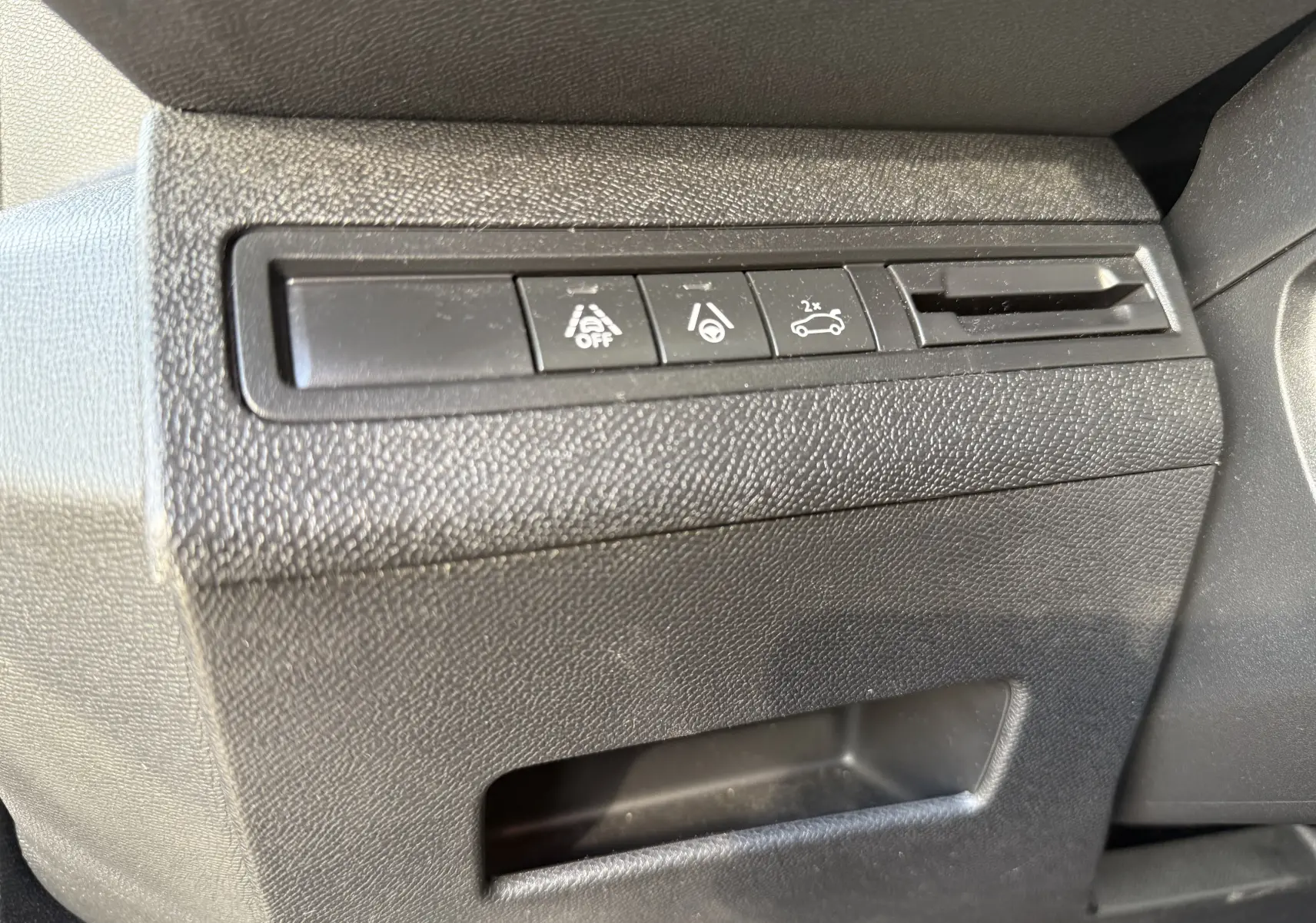 Gros plan sur les boutons de commande noirs du tableau de bord côté conducteur du Peugeot 3008 gris 2022.