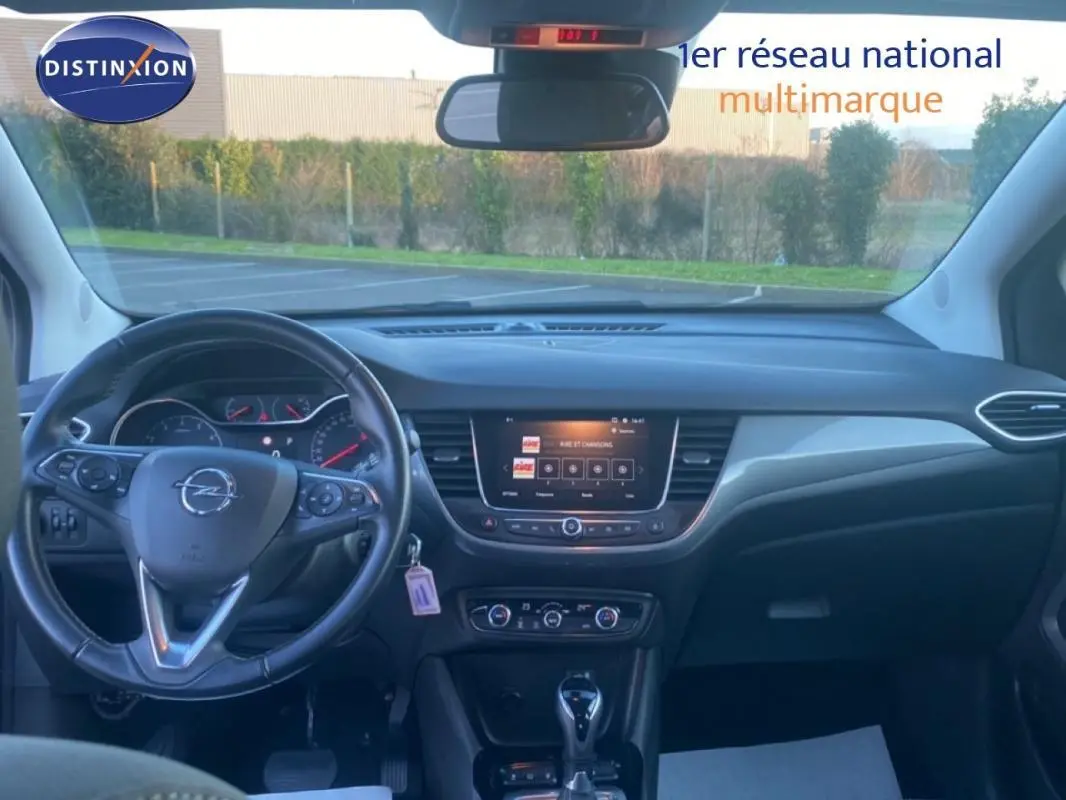 Vue intérieure frontale du tableau de bord et volant cuir noir de l'Opel Crossland 2022 avec écran tactile central et commandes multifonctions.