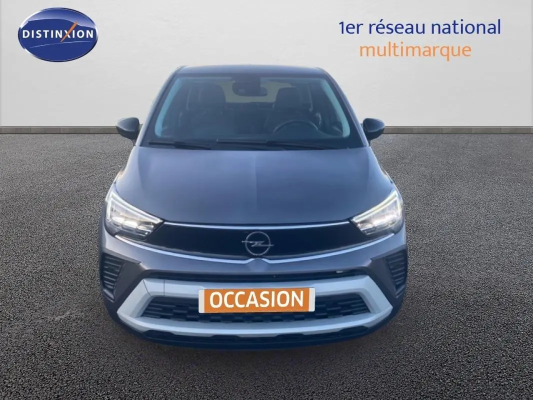 Vue avant d'un Opel Crossland gris foncé 2022 avec phares allumés et calandre noire distinctive.