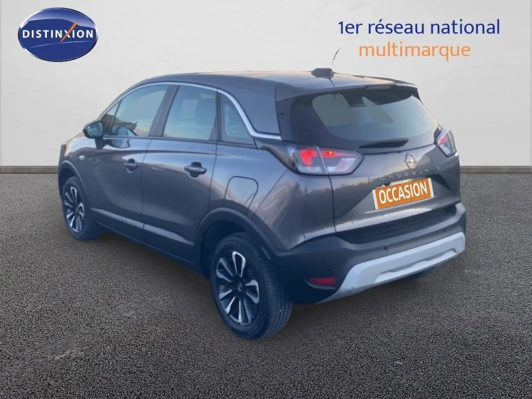 Vue 3/4 arrière d’un Opel Crossland gris foncé avec jantes alliage 17 pouces et toit panoramique visible.