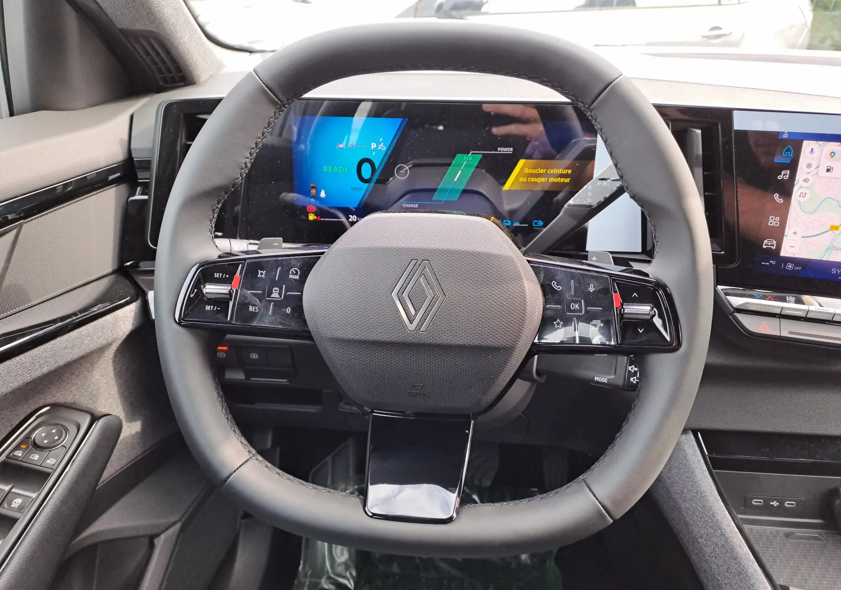 Vue rapprochée du volant noir du Renault Austral 2025 avec tableau de bord numérique et écran tactile latéral.