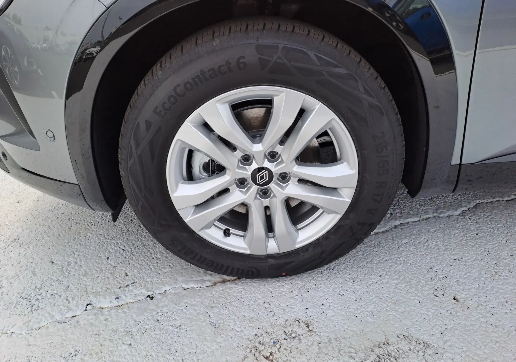 Gros plan sur la roue avant droite du Renault Austral gris schiste, mettant en valeur la jante alliage et le pneu Continental EcoContact 6.