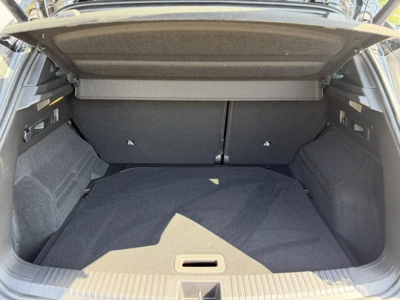 Vue intérieure du coffre ouvert du Renault Austral E-Tech Full Hybrid 2026, avec habillage gris foncé et cache-bagages déployé.