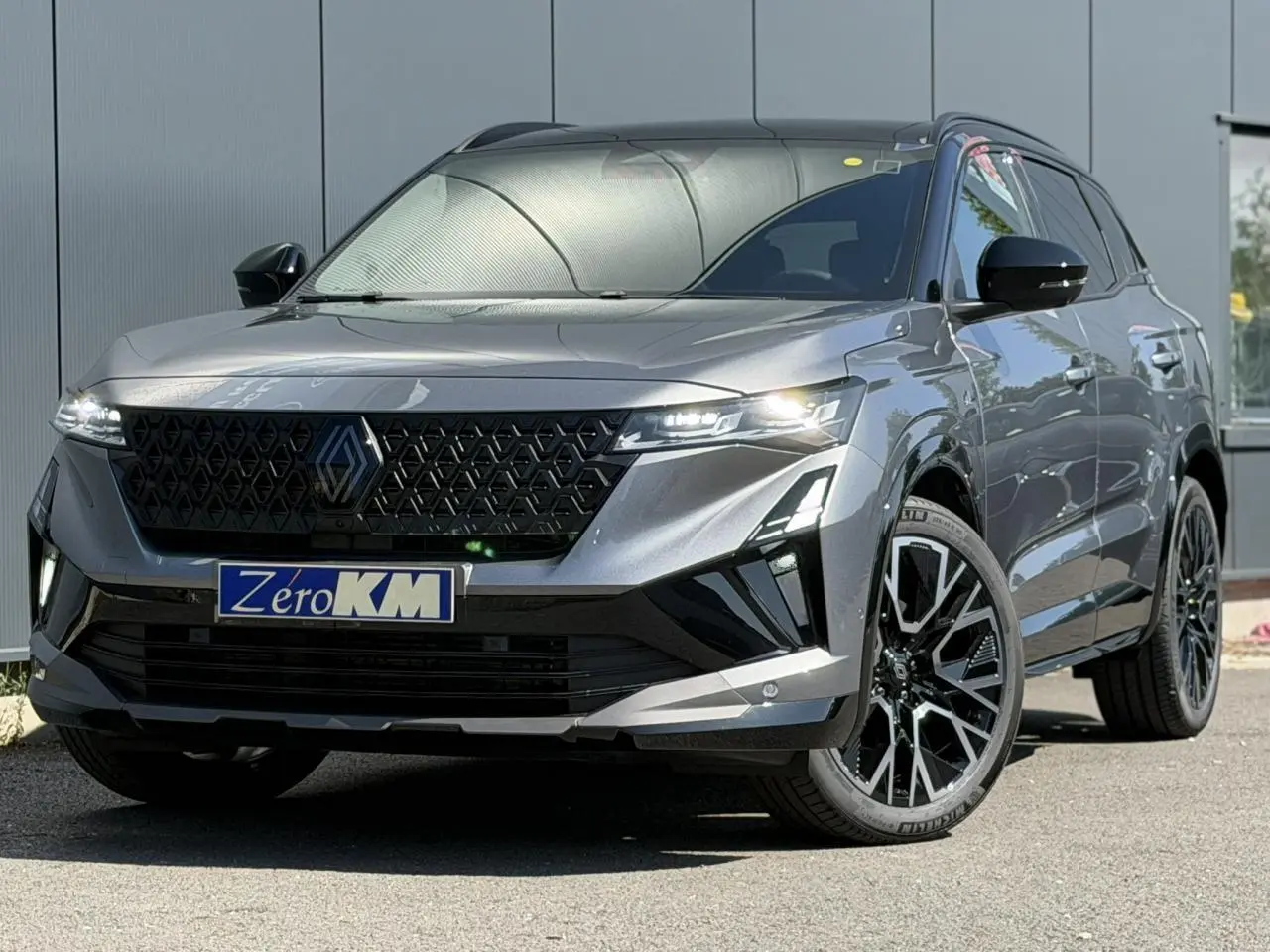 Renault Austral E-Tech gris schiste avec toit noir, vue 3/4 avant mettant en valeur la calandre et jantes noires.