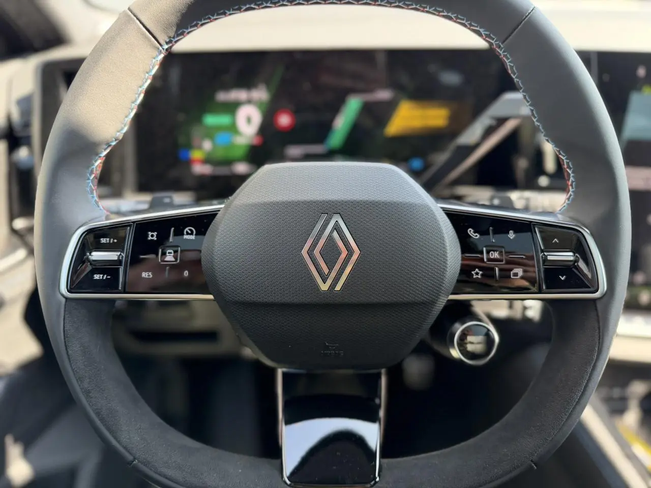 Vue rapprochée du volant textile noir avec insert Alcantara et logo Renault au centre du Renault Austral 2026.