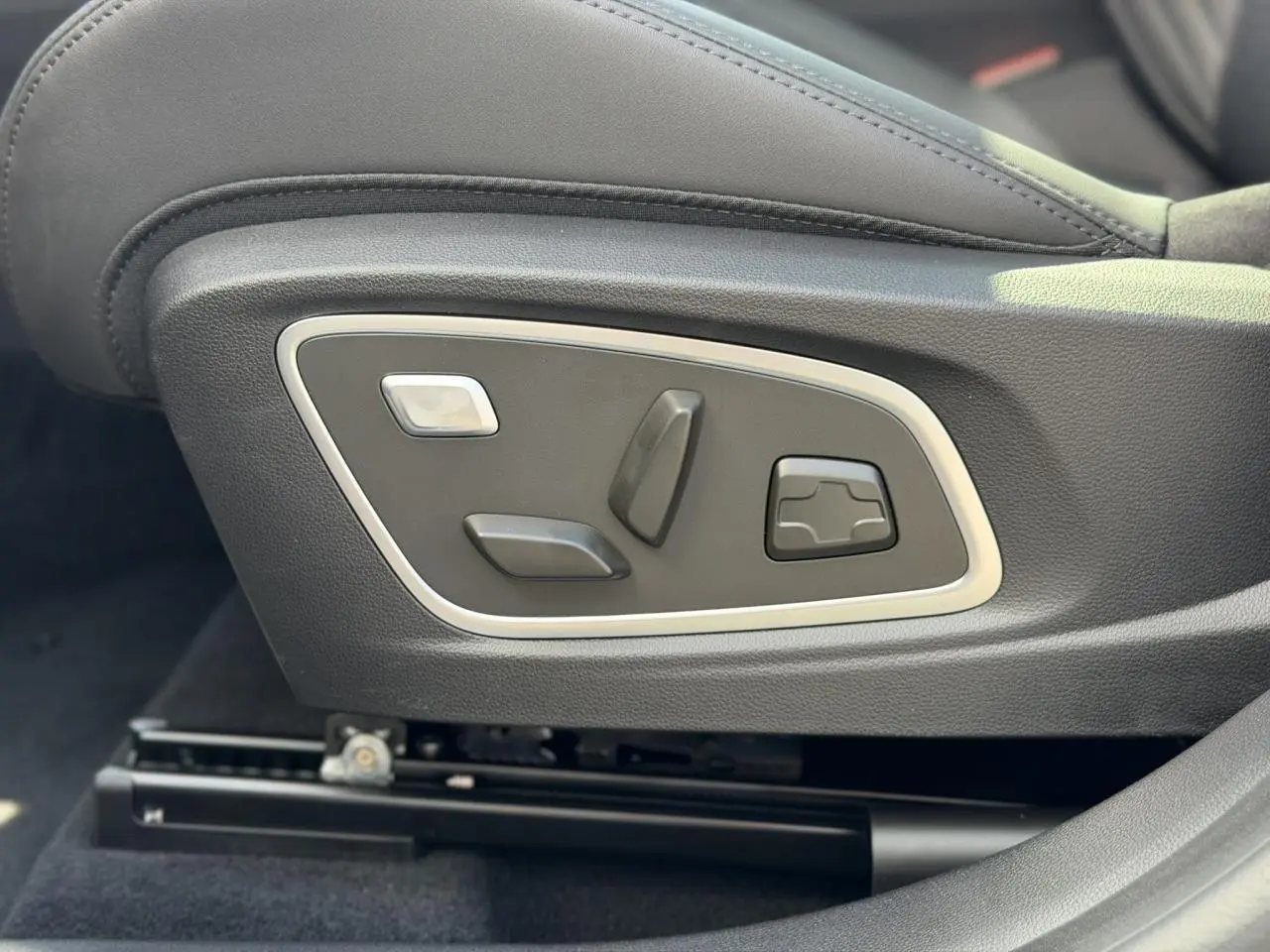 Gros plan sur les commandes électriques du siège conducteur en cuir noir du Renault Austral E-Tech Full Hybrid 2026.