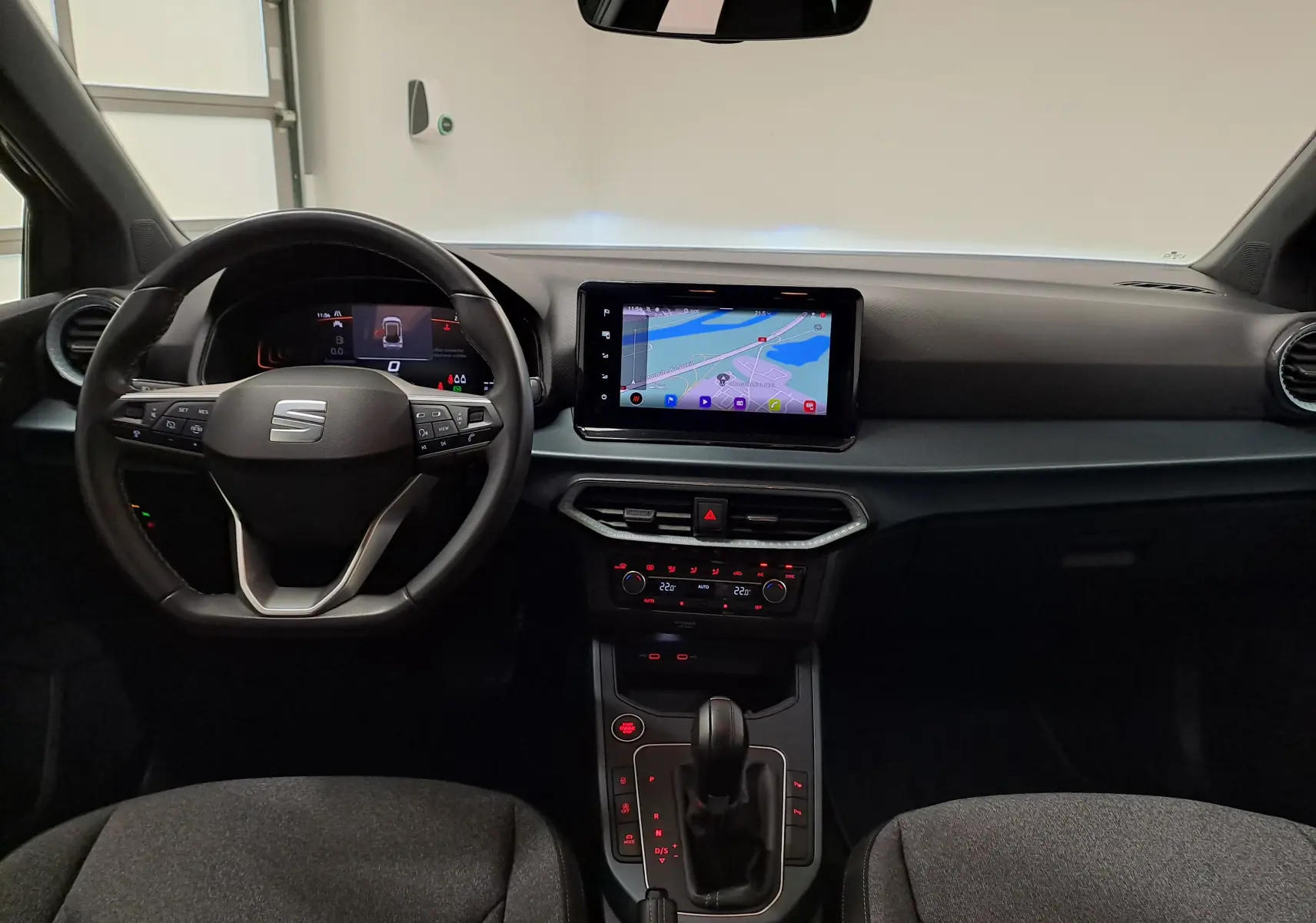 Vue intérieure avant du tableau de bord et volant du SEAT Arona 2024, avec écran tactile et commandes au volant.