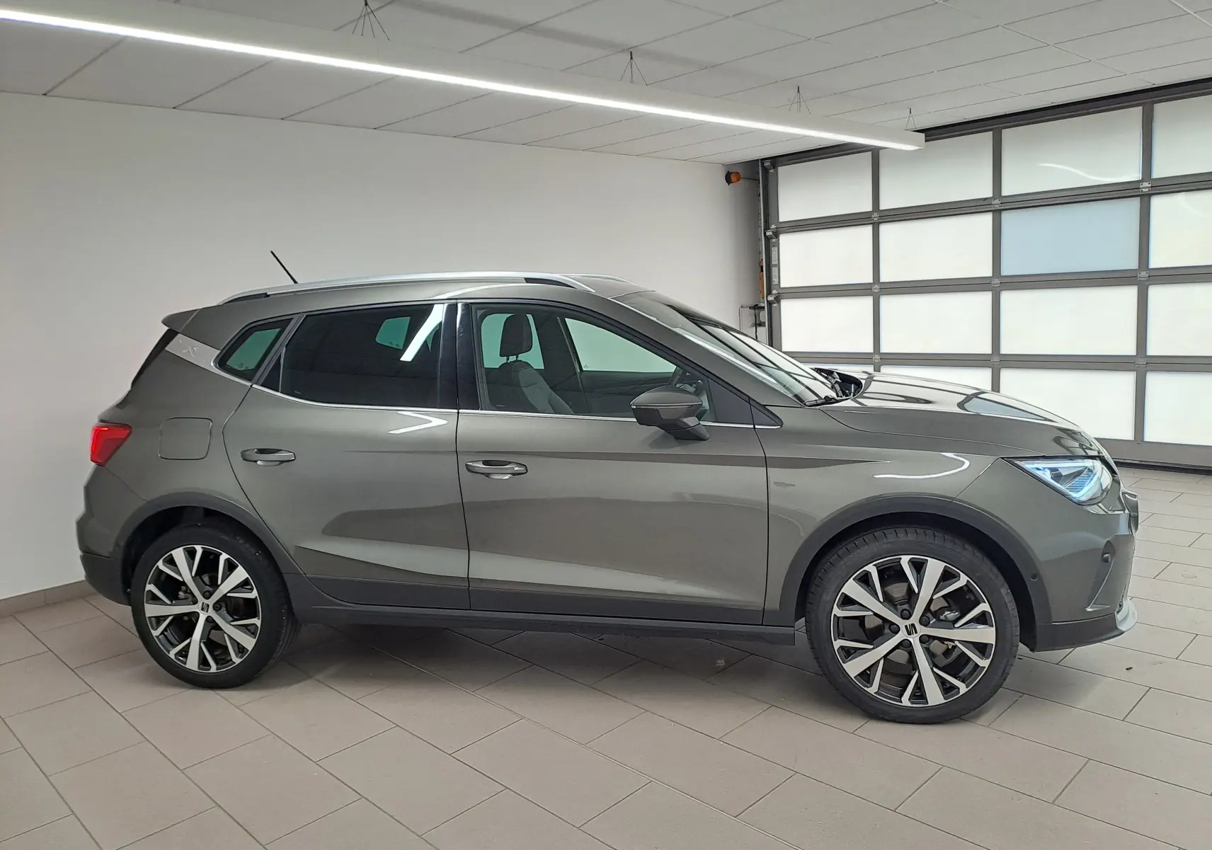 SEAT Arona 1.5 TSI 2024 gris falaise, vue profil droit, jantes alliage 18'' PERFORMANCE et vitres arrière surteintées.