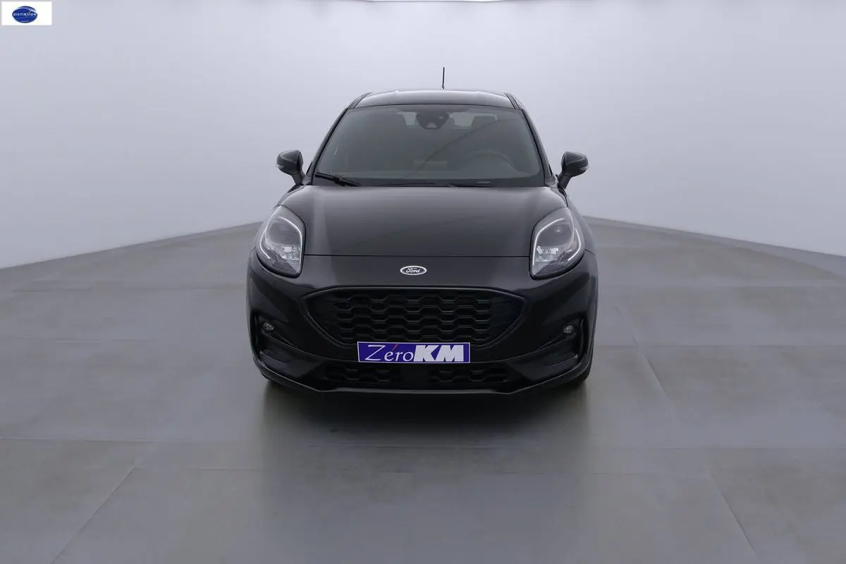 Vue frontale d'une Ford Puma noir agate métal avec calandre hexagonale et phares LED distinctifs.