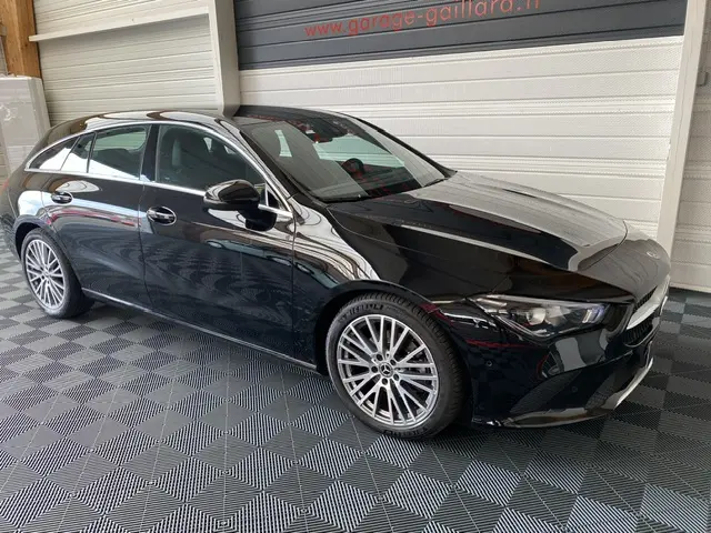 Vue 3/4 avant d'une Mercedes Classe CLA Shooting Brake noire brillante avec jantes alliage et lignes élégantes.