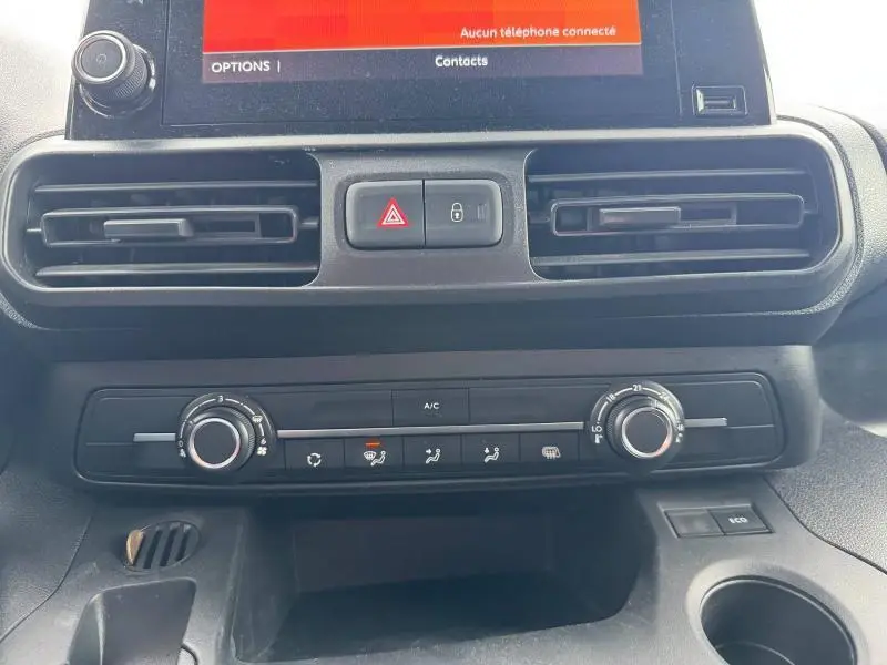 Tableau de bord du Citroën Berlingo Fourgon blanc, vue centrée sur les commandes de climatisation et les aérateurs noirs.