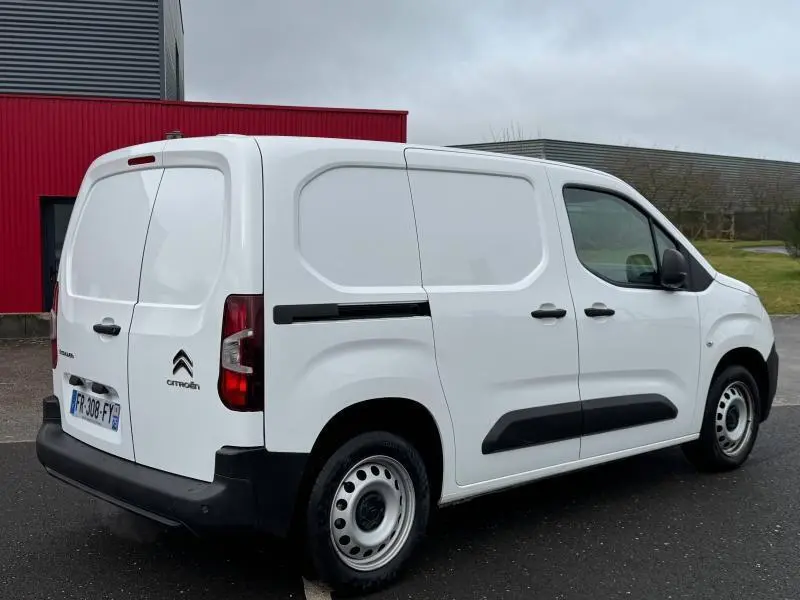 Vue 3/4 arrière droite d'un Citroën Berlingo Fourgon blanc Banquise avec portes battantes arrière et protections noires.