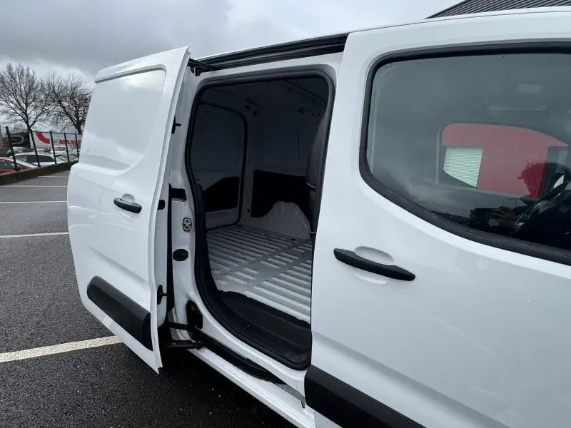 Vue latérale gauche rapprochée du Citroën Berlingo Fourgon blanc Banquise avec porte coulissante ouverte sur l’espace de chargement vide.