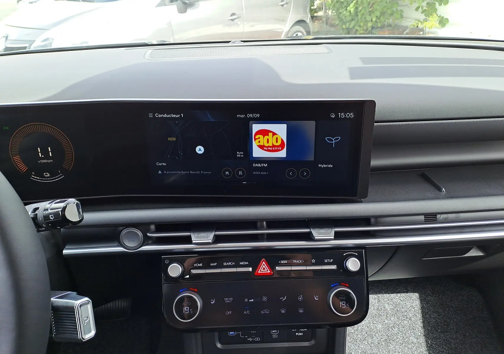 Intérieur du Hyundai Tucson 2025 en vue frontale, tableau de bord noir avec écran tactile et commandes climatisation digitales.