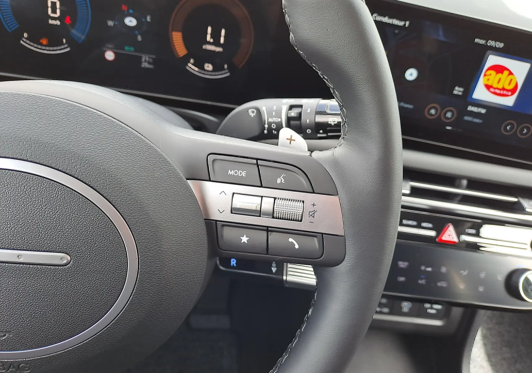 Vue rapprochée du volant noir du Hyundai Tucson 2025 avec commandes intégrées et tableau de bord numérique lumineux.