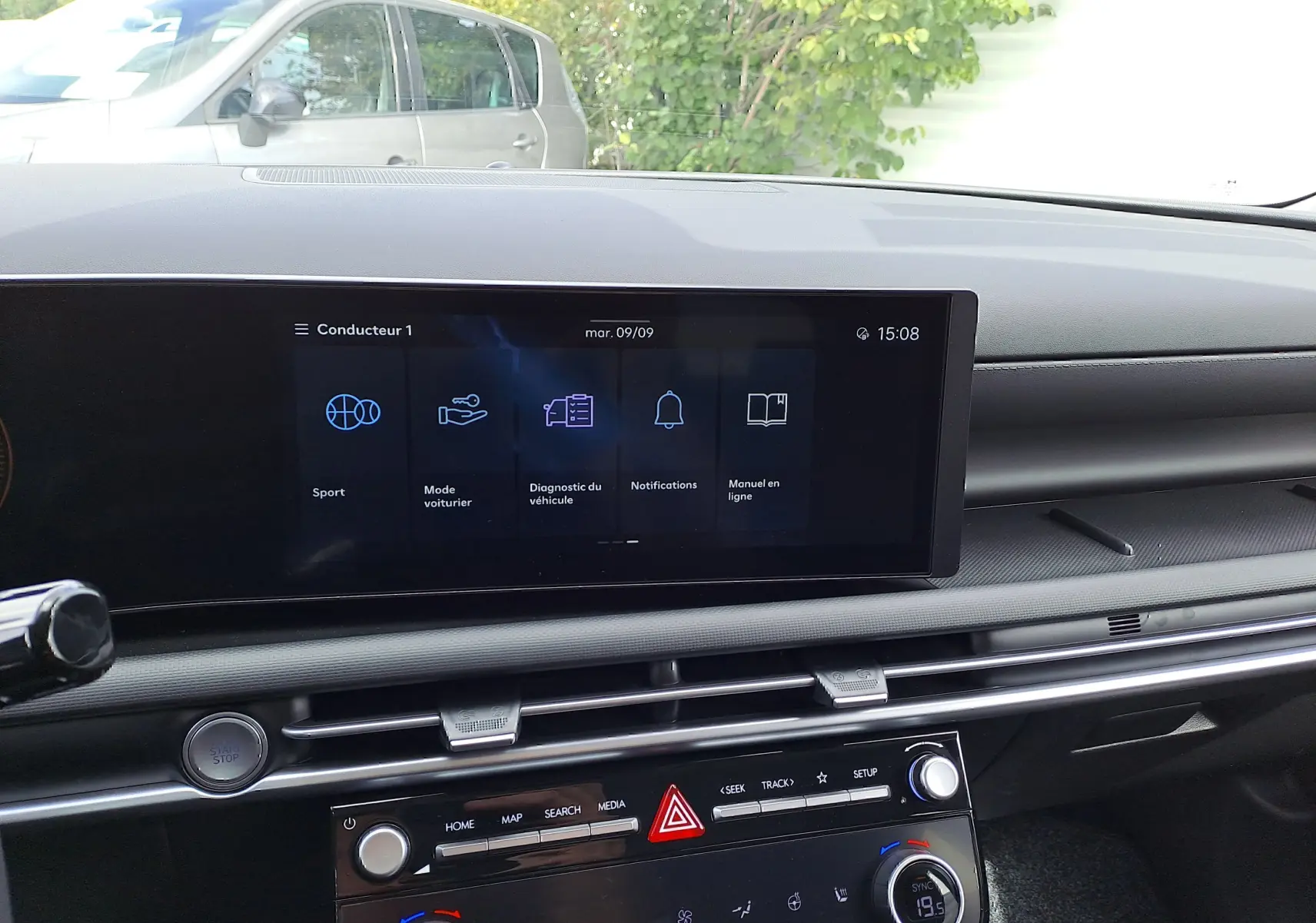 Vue intérieure du tableau de bord du Hyundai Tucson 2025 avec écran tactile central et commandes climatisation visibles.