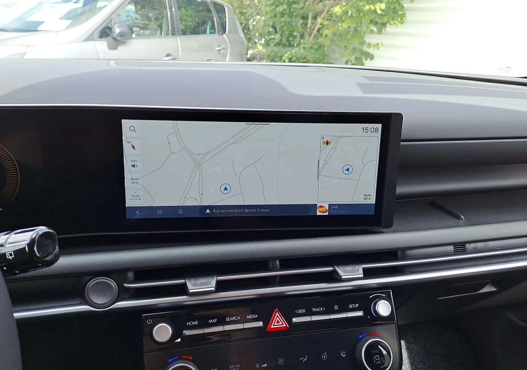 Vue intérieure du tableau de bord du Hyundai Tucson 2025 avec écran tactile affichant la navigation et commandes climatisation.
