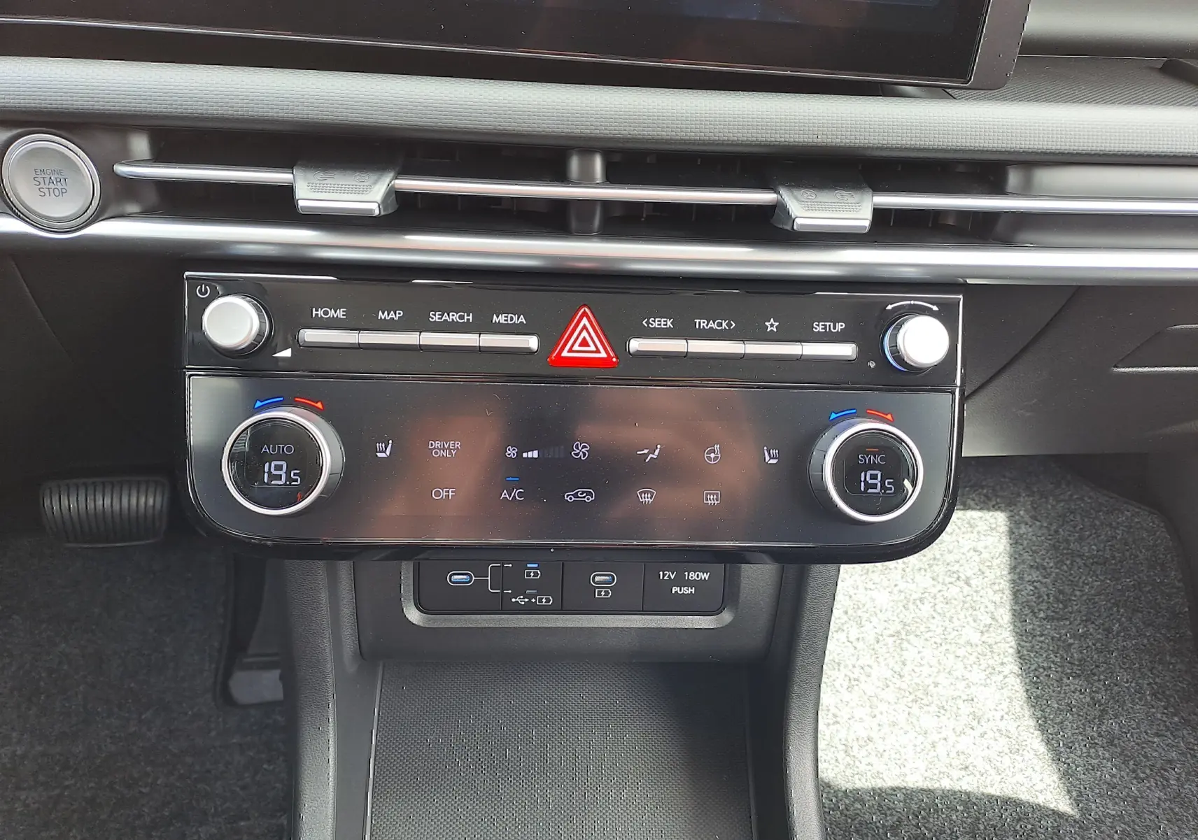 Vue rapprochée de la console centrale du Hyundai Tucson 2025, avec commandes climatisation digitale et bouton start/stop.