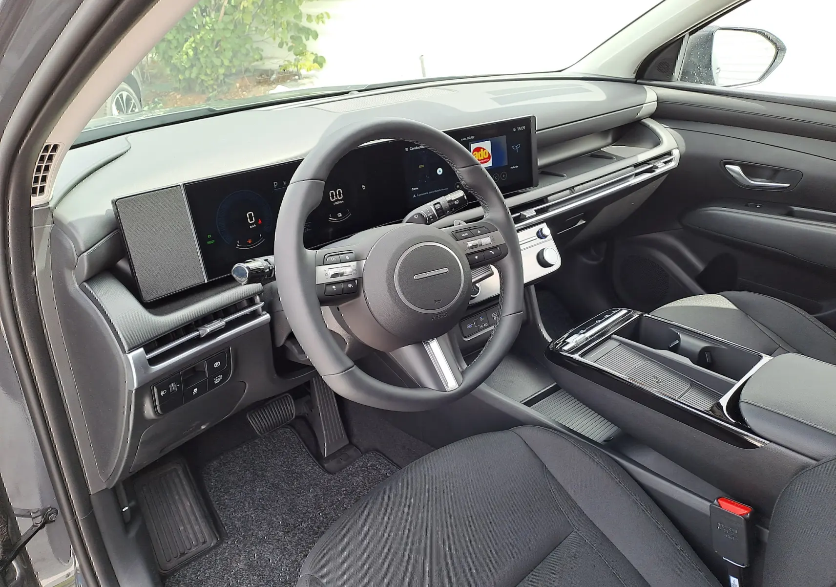 Vue intérieure côté conducteur du Hyundai Tucson 2025 gris Ecotronic, tableau de bord numérique et console moderne noire.