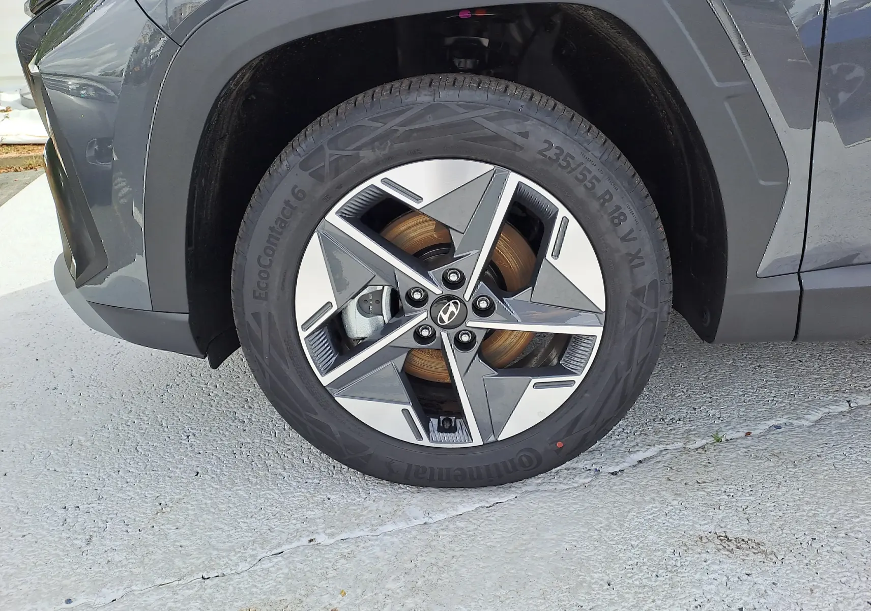 Gros plan sur la roue avant gauche du Hyundai Tucson 2025 gris Ecotronic avec jante alliage bicolore et logo Hyundai central.