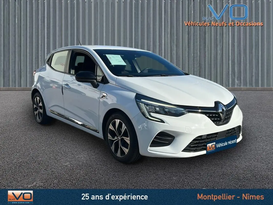 Vue 3/4 avant droite d'une Renault Clio blanche V TCe 90 - 21 Limited avec jantes alliage 16 pouces sur sol gris.