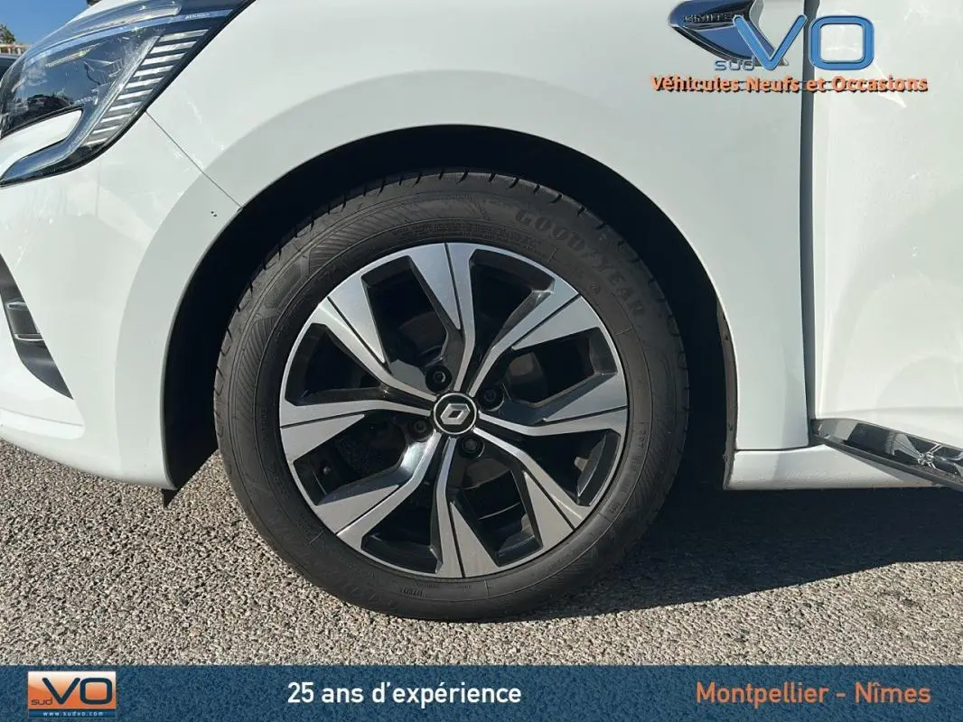 Gros plan sur la roue avant gauche d'une Renault Clio blanche 2021 avec jante alliage 16 pouces au design moderne.